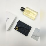 Этот практичный и изящный карман для карт Dior Saddle Flip Clutch может заменить