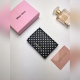 Игривый принт в горошек от Miu Miu украшает этот изящный и лаконичный чехол для 