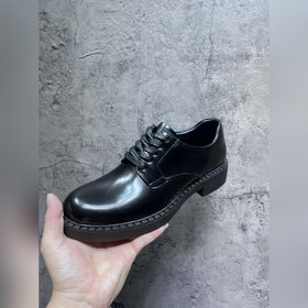Мужские лоферы Prada 2023 ранней осени с треугольным логотипом. О