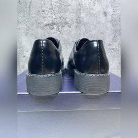 Мужские лоферы Prada 2023 ранней осени с треугольным логотипом. О