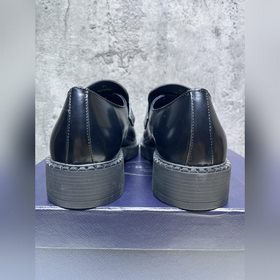 Мужские лоферы Prada 2023 ранней осени с треугольным логотипом. О