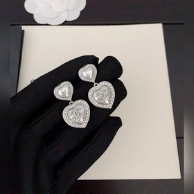 Новейшие серьги Chanel белого и золотистого цвета в форме сердца.
