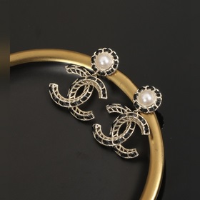 Сережки Chanel из черного металла с бледно-золотыми элементами. С