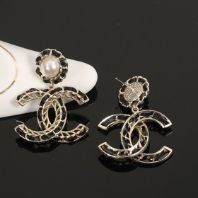Сережки Chanel из черного металла с бледно-золотыми элементами. С