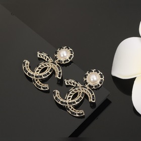 Сережки Chanel из черного металла с бледно-золотыми элементами. С