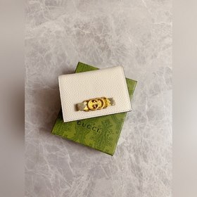 Новейшая модель Gucci — маленький кошелек с бантиком из змеиной к