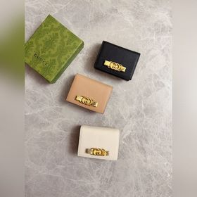 Новейшая модель Gucci — маленький кошелек с бантиком из змеиной к