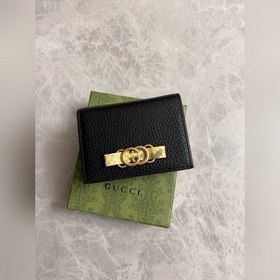 Новейшая модель Gucci — маленький кошелек с бантиком из змеиной к