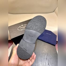 Обувь Prada изготовлена из блестящей кожи с эффектом Fumé. Полнос